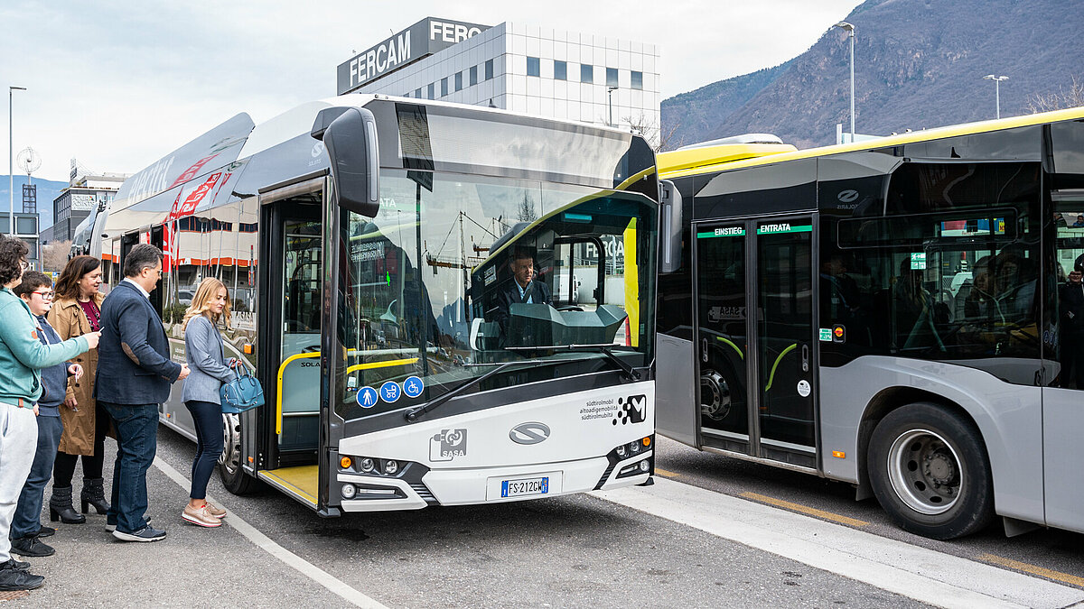 Passengers are taking an electric urban bus.